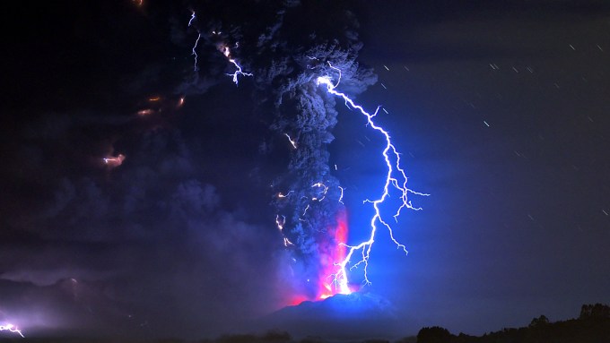 A lightning bolt piercing smoke and lava from a volcanic eruption