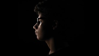 A photo of a teen boy's profile with the light shining just on his face.