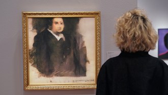 photo of a person looking at the "Edmond de Belamy" portrait